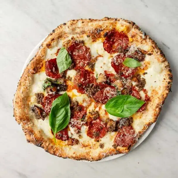 Alessandro pizza topped with eggplant, fior di latte, spicy hot salami, black truffle, shaved Parmesan, and fresh basil