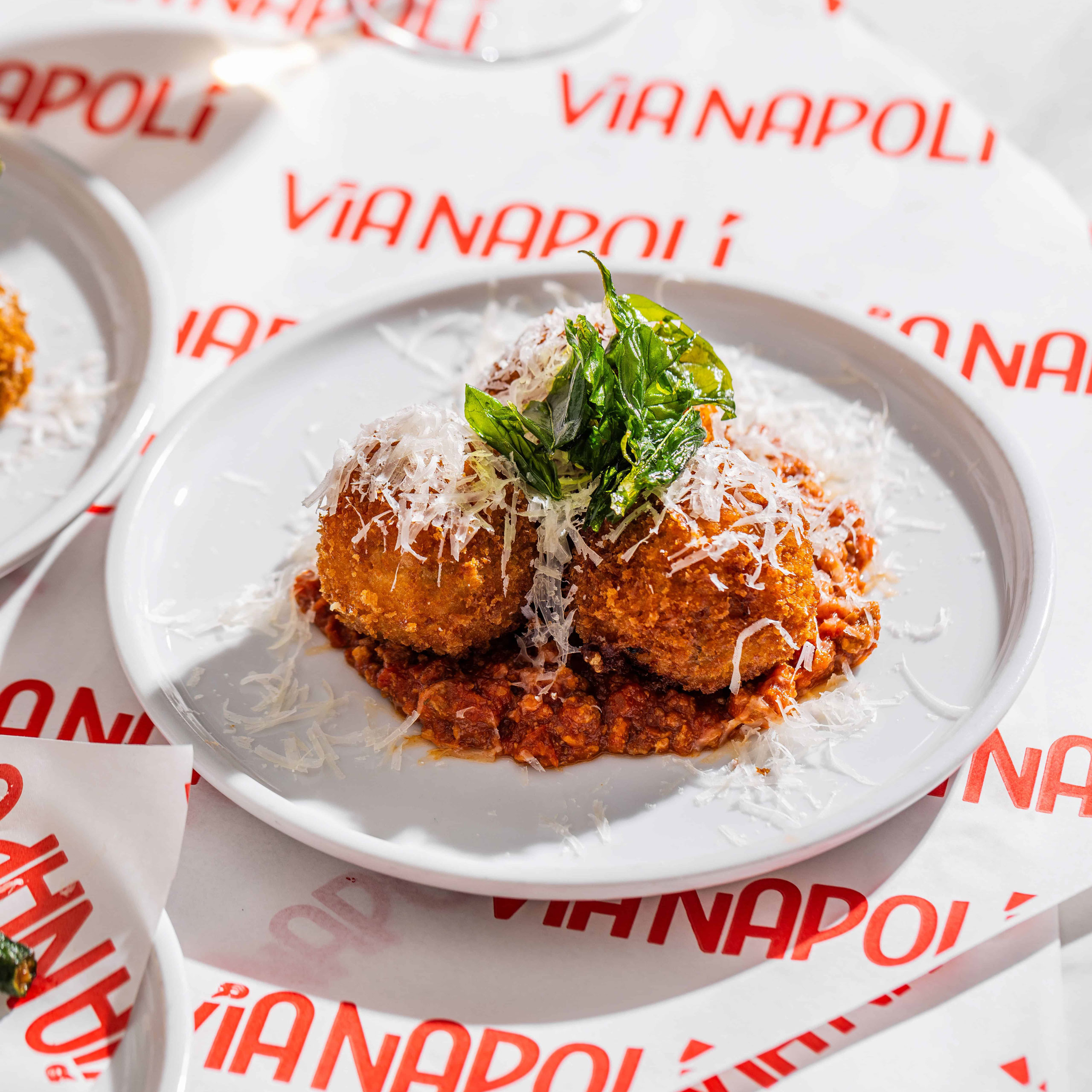 Traditional arancini filled with slow cooked beef and pork Bolognese, green peas, and melted buffalo mozzarella