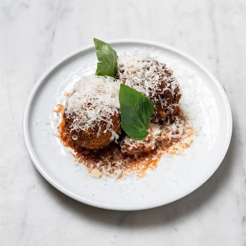 Traditional arancini filled with slow cooked beef and pork Bolognese, green peas, and melted buffalo mozzarella