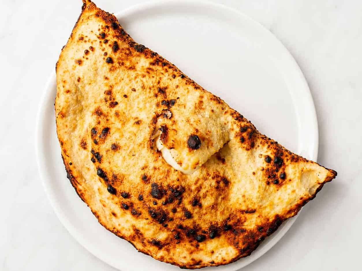 Calzone - Folded Pizza, Solania San Marzano, Fior di Latte, Buffalo Ricotta, Pepper, Basil, EVOO. Choice of Double Smoked Shoulder Ham or Mild Neapolitan Salami