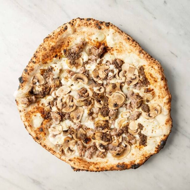 Elena pizza topped with fior di latte, Italian sausage, mushrooms, aromatic truffle, and fresh basil