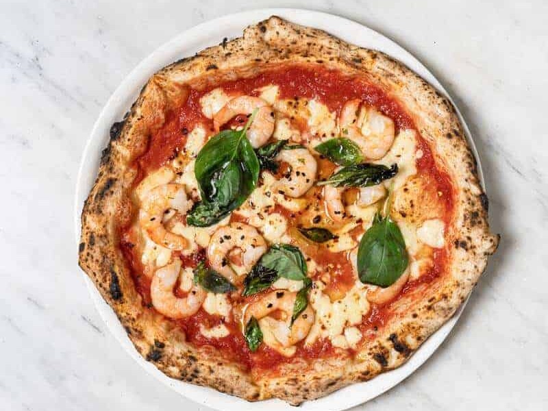 Gamberi pizza topped with Solania San Marzano tomatoes, Fior di Latte, prawns, garlic, chilli, fresh basil, and EVOO at Via Napoli
