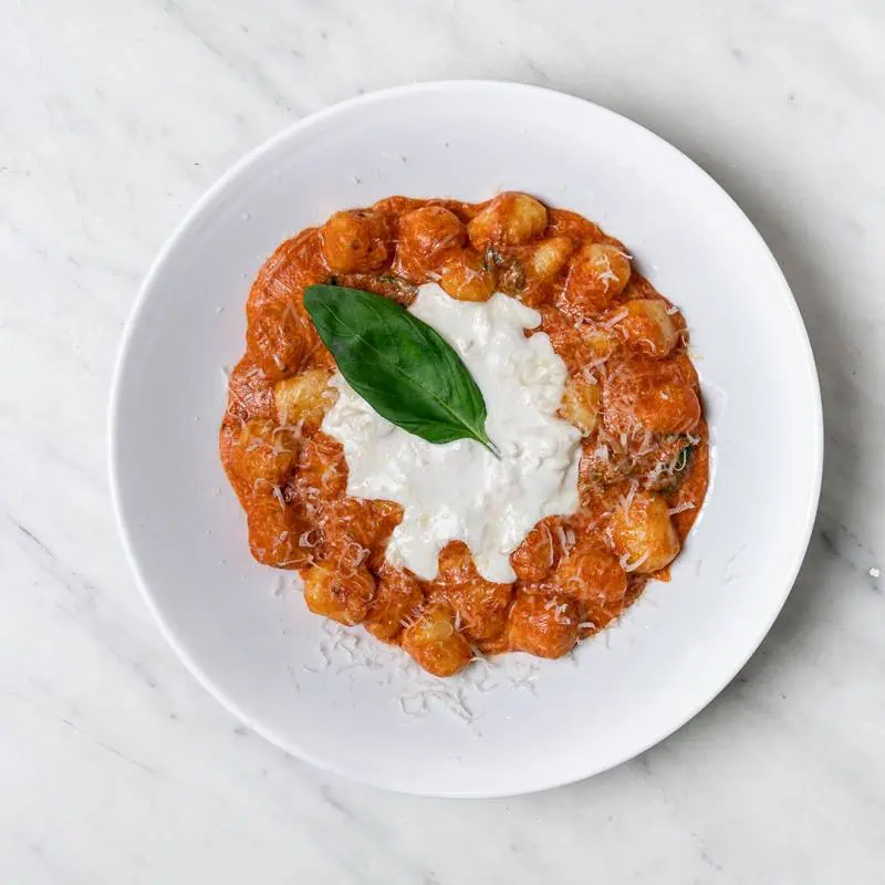 Gnocchi Sorrentina in San Marzano tomato sauce with melted buffalo mozzarella, Grana Padano DOP, basil, and EVOO at Via Napoli