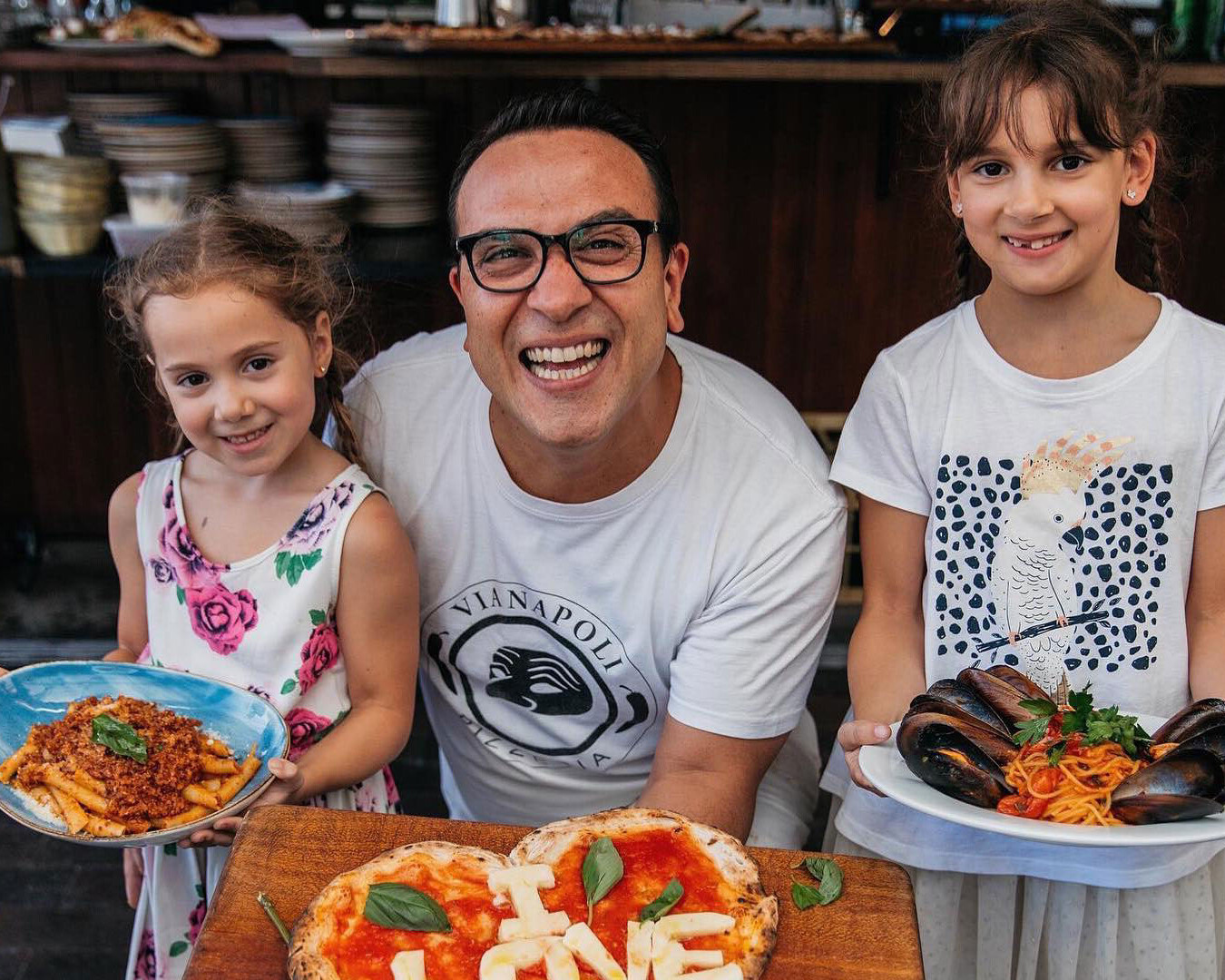 Luigi Espositio and children with pizza and Italian food