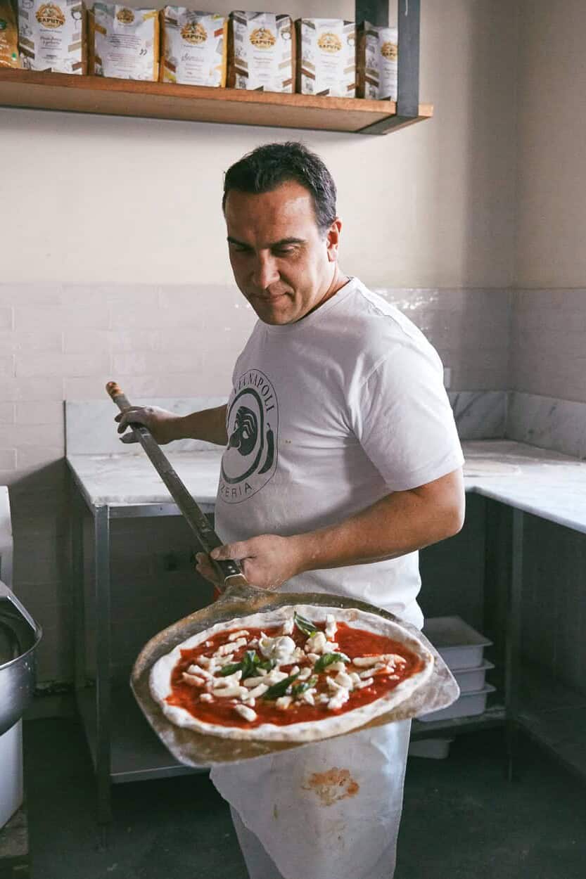 Luigi Esposito preparing pizza with peel Via Napoli kitchen