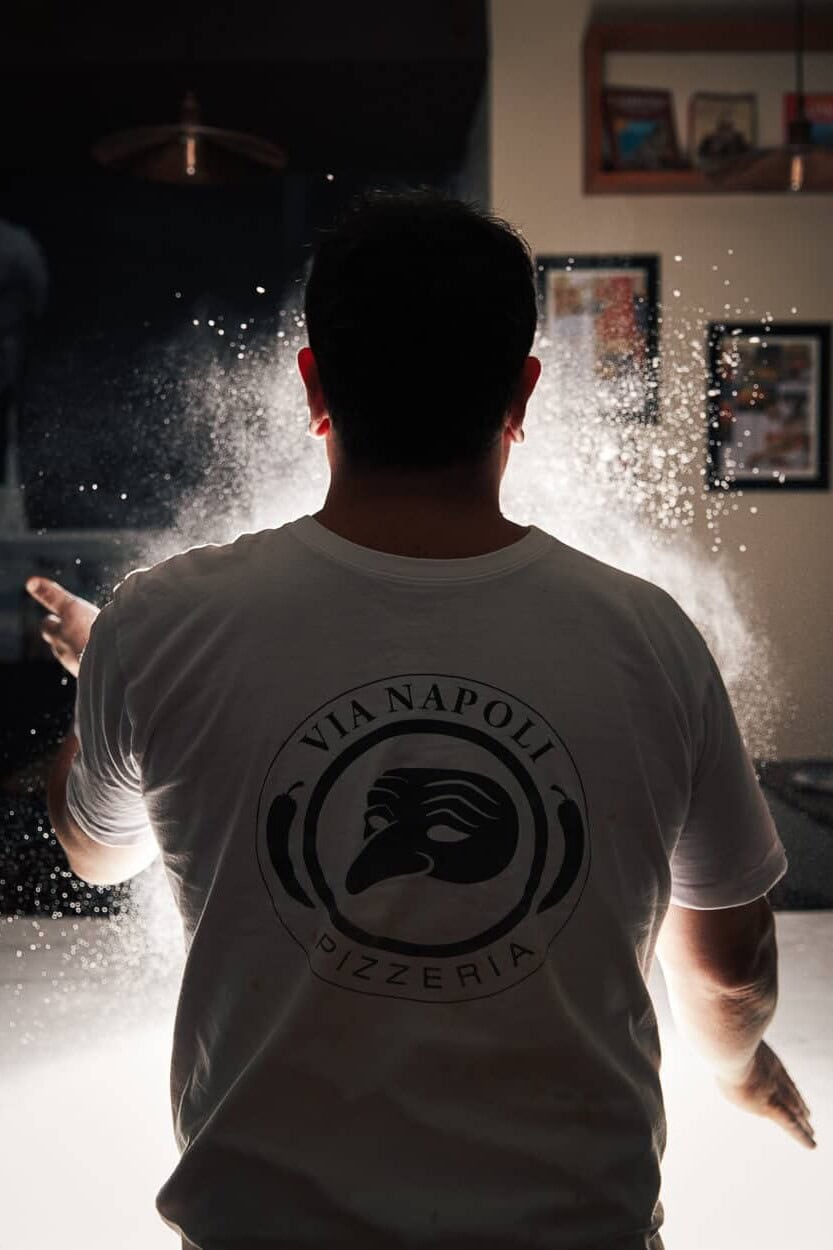 Luigi Esposito rear view dusting flour Via Napoli pizzeria