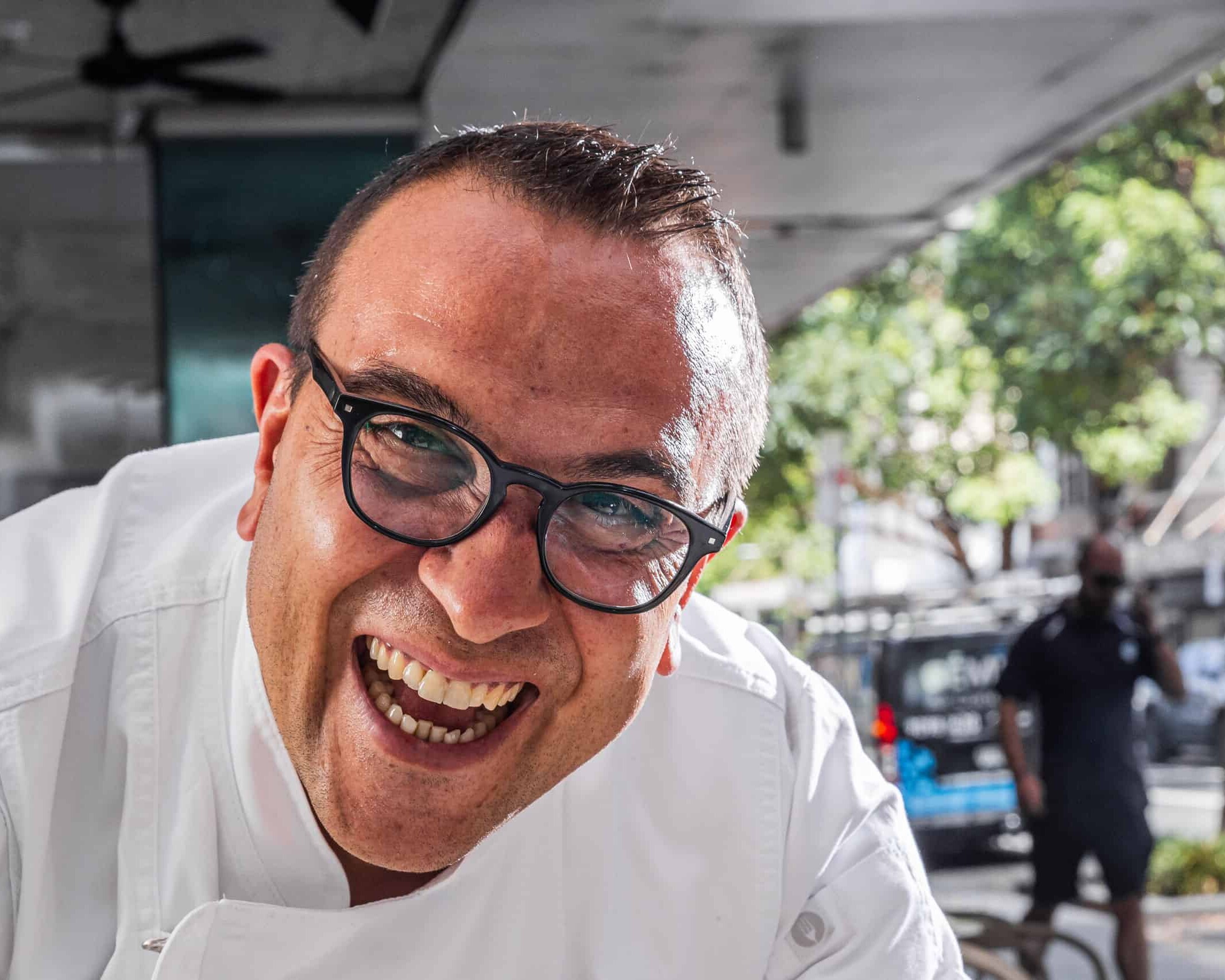 Master Pizzaiolo Luigi Esposito from Via Napoli Pizzeria smiling in white uniform on a sunny street