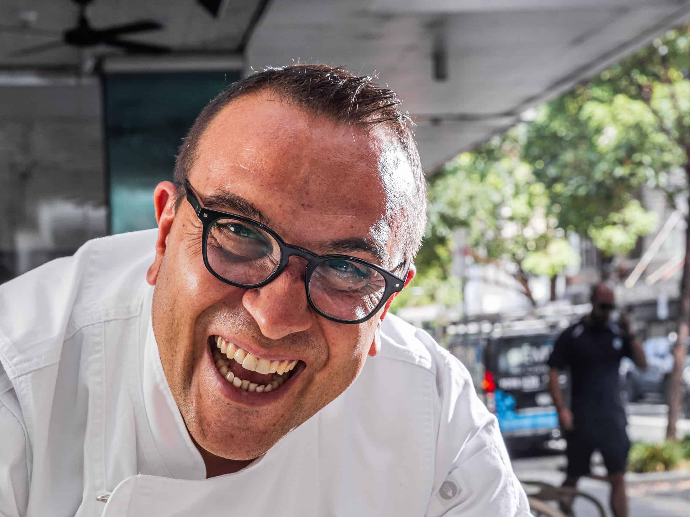 Master Pizzaiolo Luigi Esposito from Via Napoli Pizzeria smiling in white uniform on a sunny street