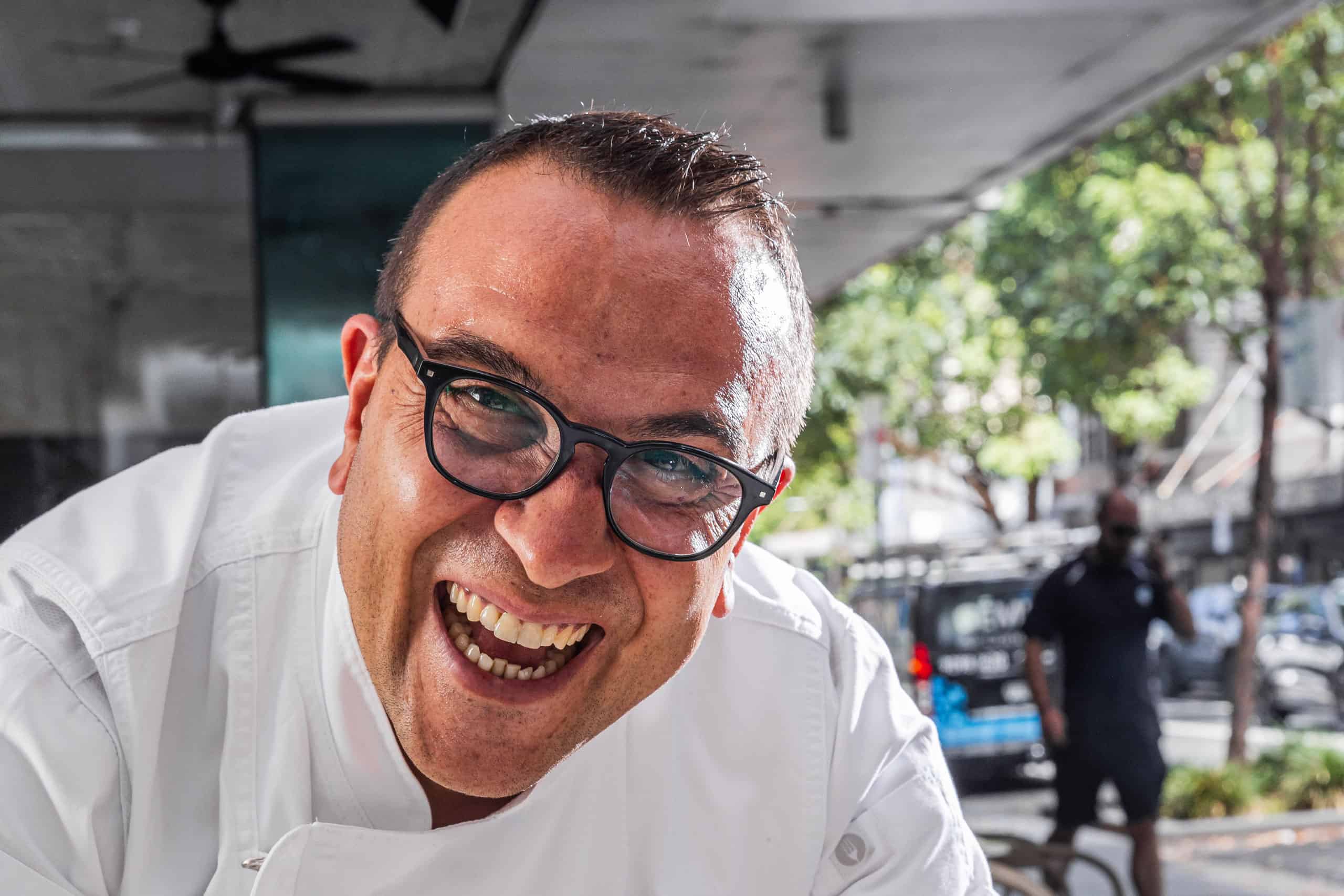 Master Pizzaiolo Luigi Esposito from Via Napoli Pizzeria smiling in white uniform on a sunny street