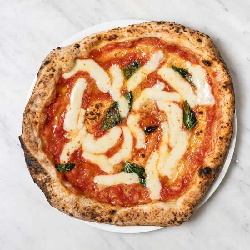 Classic Margherita pizza topped with creamy buffalo mozzarella, San Marzano tomato, and fresh basil