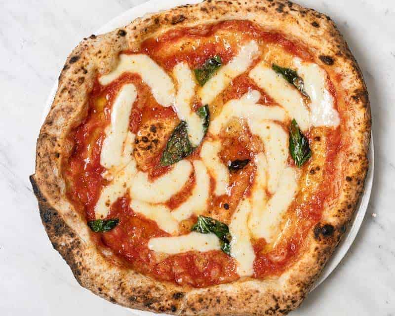 Margherita pizza topped with Solania San Marzano tomatoes, Fior di Latte, Pecorino Romano, Grana Padano DOP, fresh basil, and EVOO at Via Napoli