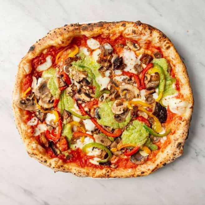 Ortolana pizza topped with fior di latte, San Marzano tomato, eggplant, mushrooms, roasted capsicum, zucchini purée, and fresh basil