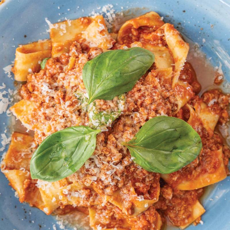 Homemade pappardelle pasta served with a rich 5-hour slow cooked beef and pork ragù, traditional soffritto, and 36-month aged Parmigiano Reggiano