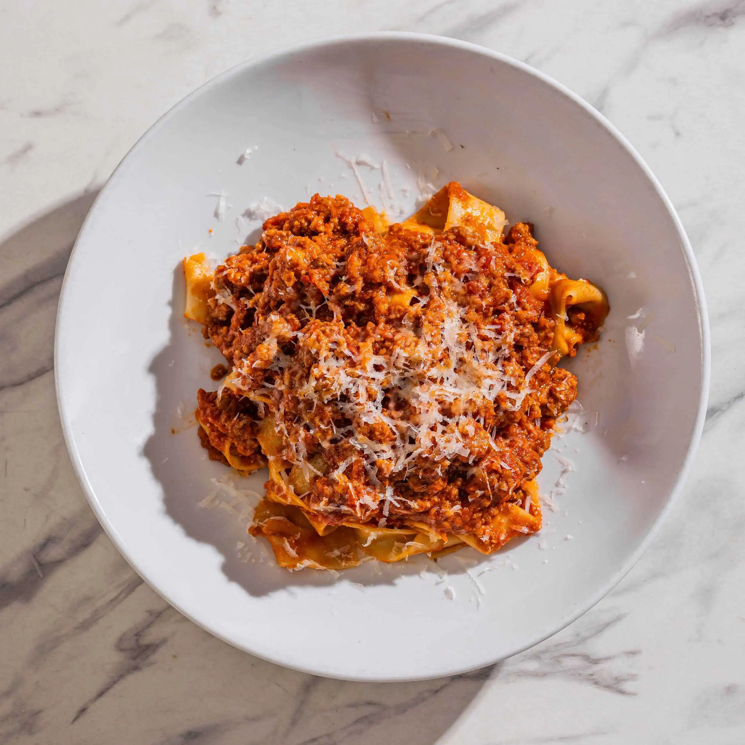 Pappardelle Bolognese topped with 5-hour slow-cooked veal and pork ragu, traditional soffritto, and Grana Padano DOP at Via Napoli