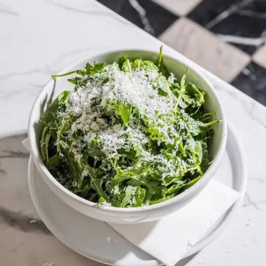 Fresh rucola salad made with peppery rocket, shaved truffle pecorino, and a honey truffle dressing