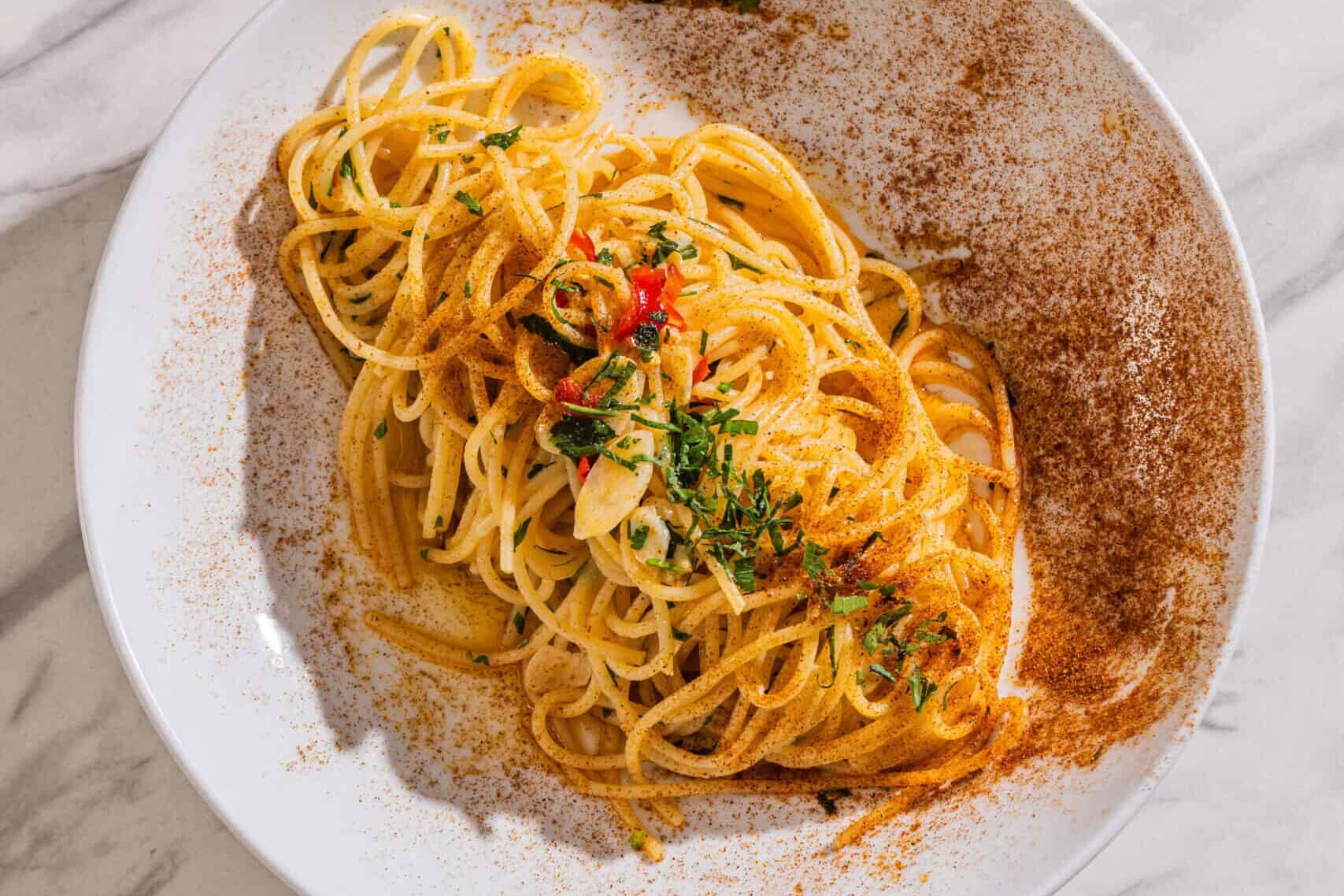 Spaghetti Aglio, Olio e Peperoncino — a simple Italian pasta dish tossed with chilli, garlic, and extra virgin olive oil, garnished with parsley