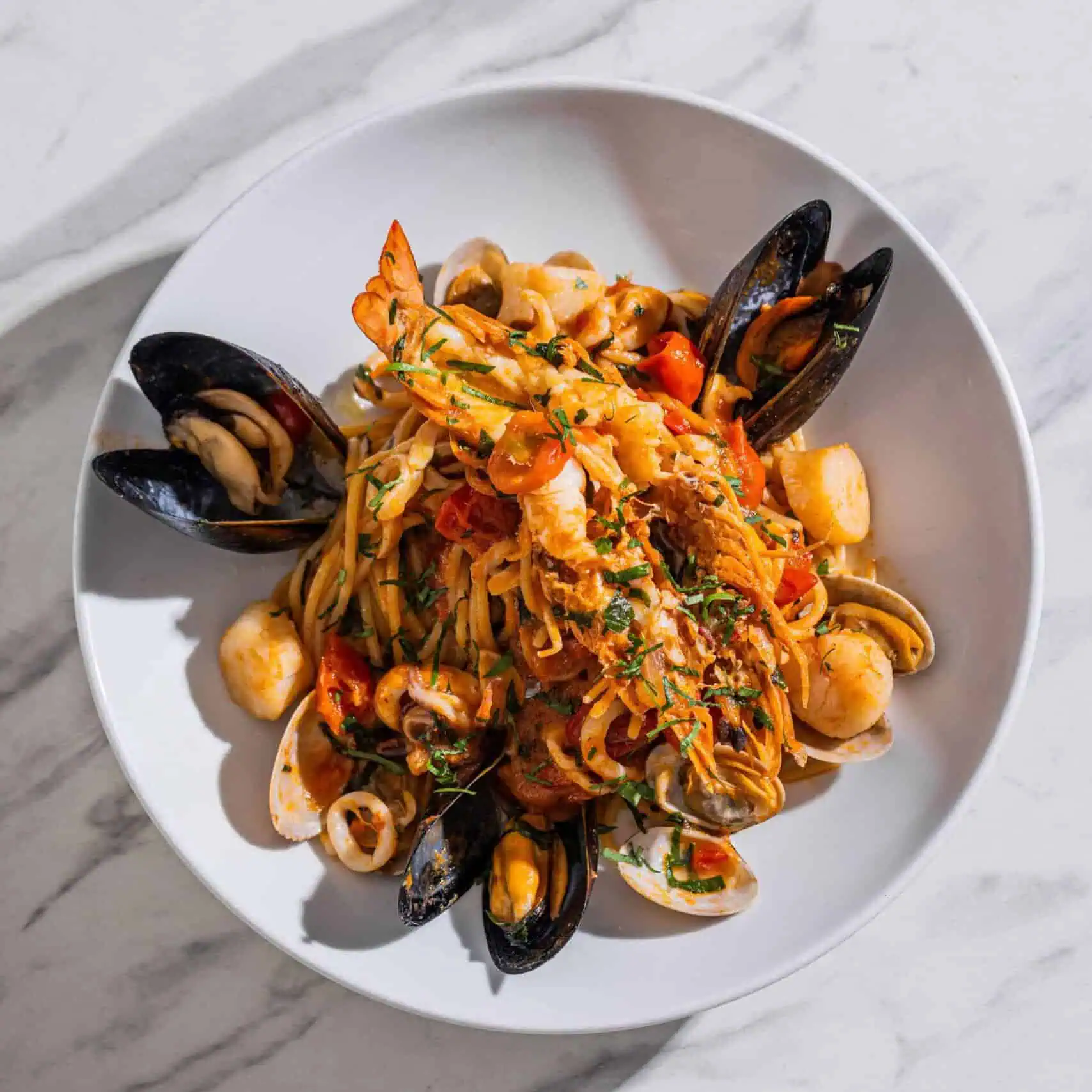 Spaghetti Marechiaro pasta with prawns, Hawkesbury River calamari, Victorian scallops, mussels, vongole, chilli, garlic, and cherry tomato truss sauce