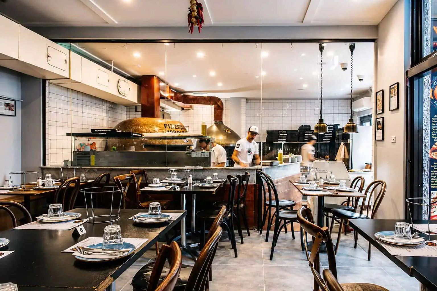 Interior of Via Napoli Pizzeria in Lane Cove featuring wood-fired pizza oven and dining tables