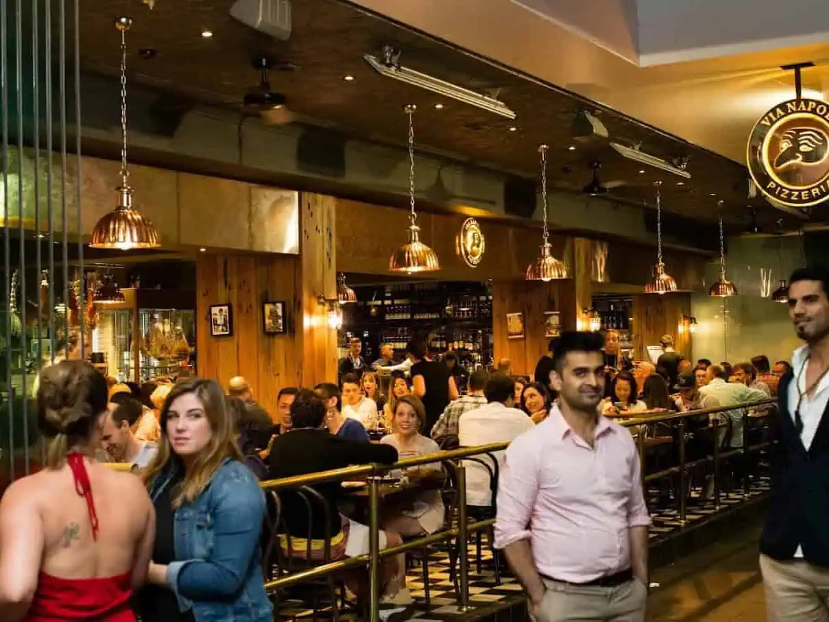 Interior view of Via Napoli Pizzeria in Surry Hills with diners enjoying Italian cuisine in a lively atmosphere.