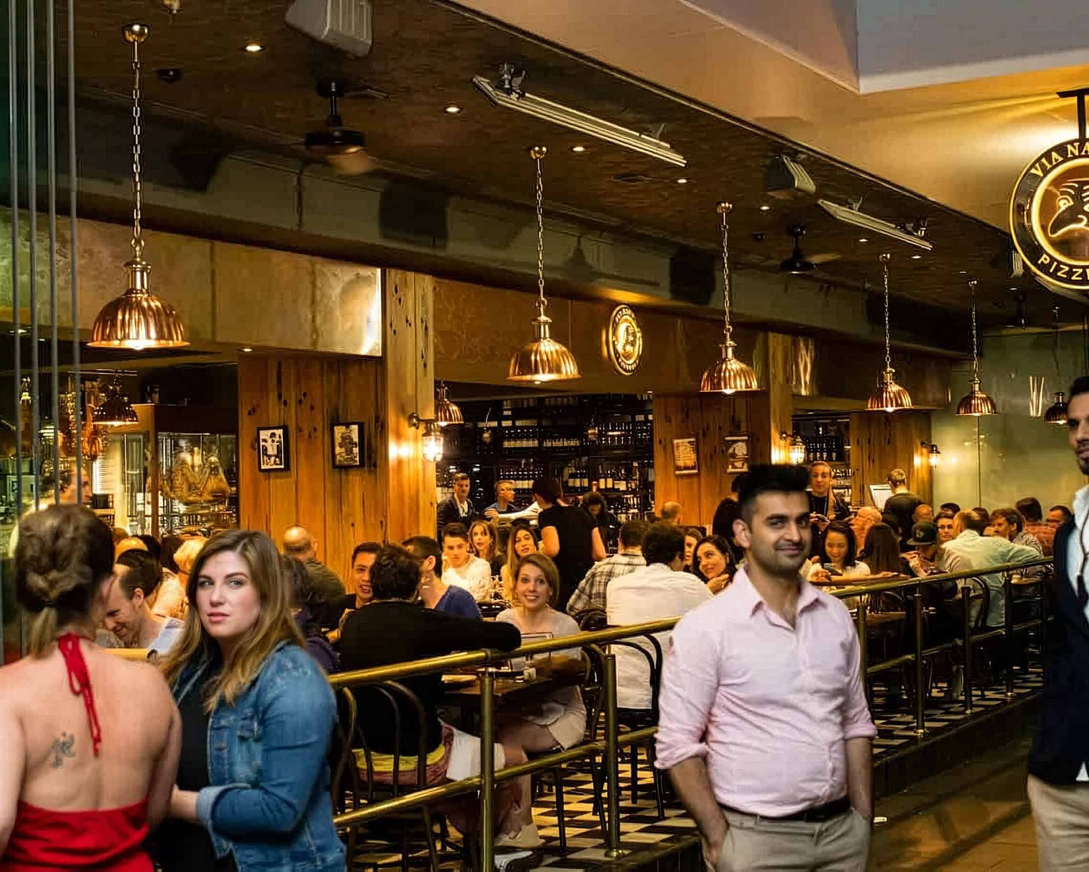 Interior view of Via Napoli Pizzeria in Surry Hills with diners enjoying Italian cuisine in a lively atmosphere.