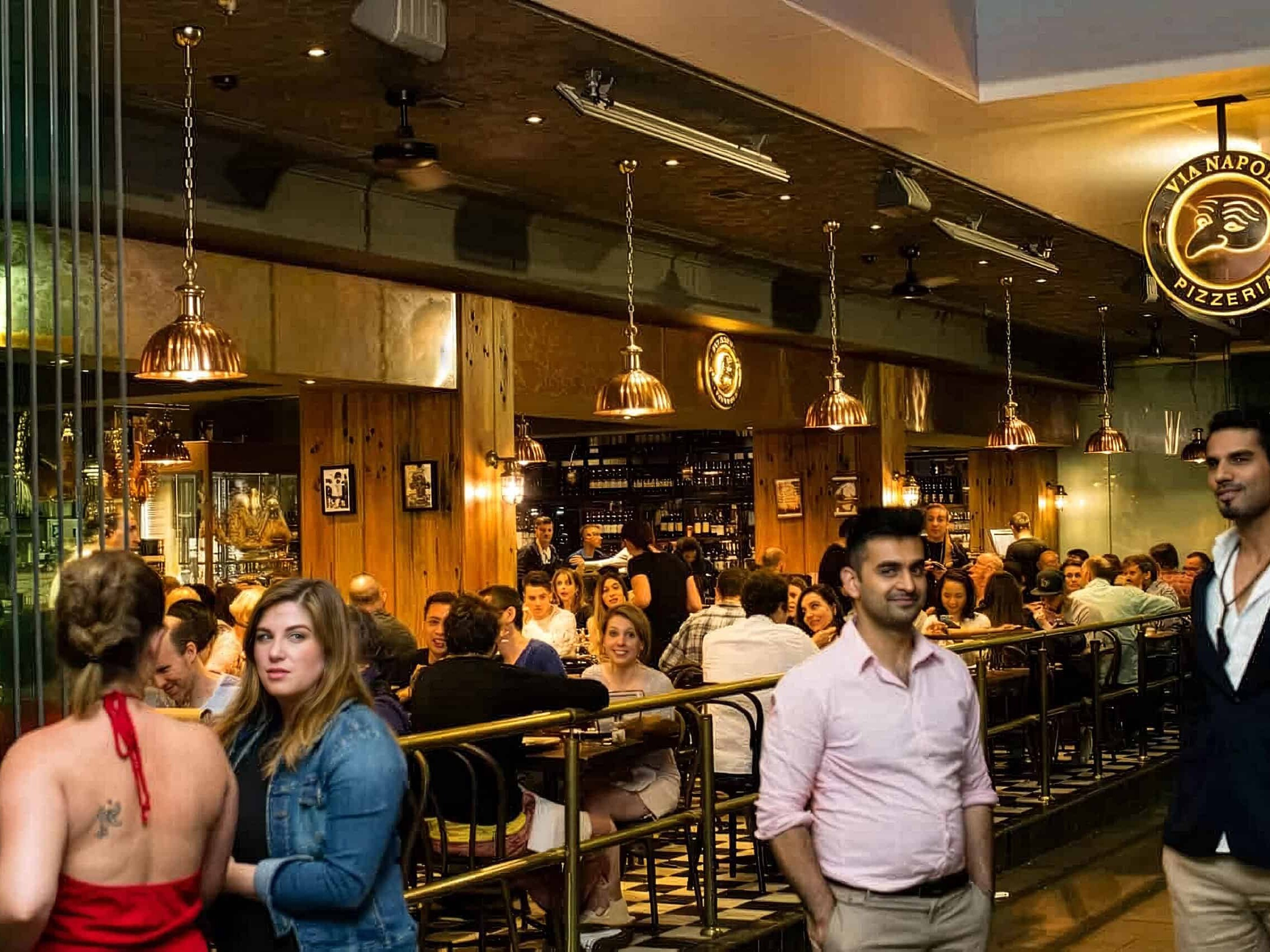 Interior view of Via Napoli Pizzeria in Surry Hills with diners enjoying Italian cuisine in a lively atmosphere.
